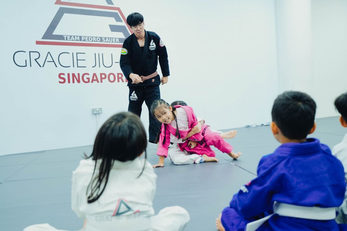 A coach guides the kids' class through a technique.